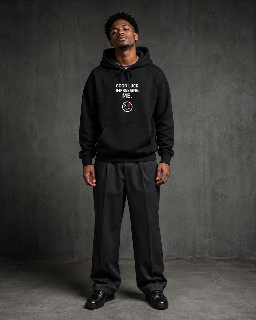 Black male model wearing the Thread Snark Good Luck Impressing Me black statement hoodie